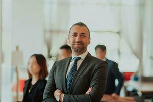 Portrait of a businessman in a suit with his arms crossed in a modern office building photo