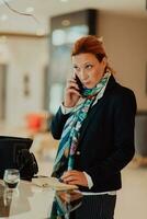 foto de un mayor mujer utilizando un teléfono inteligente a llevar fuera negocio proyectos y Tareas en un moderno sociedad