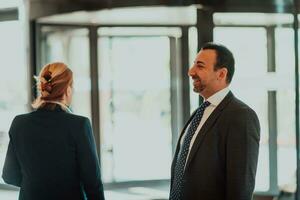 Photo of a businessman and businesswoman discussing business projects in a modern corporation. Selective focus