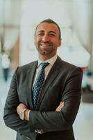 Portrait of a businessman in a suit with his arms crossed in a modern office building photo