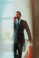 Photo of a businessman in a modern company using a smartphone. Selective focus