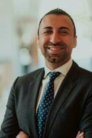 Portrait of a businessman in a suit with his arms crossed in a modern office building photo