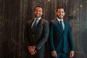 Portrait of two businessmen in a suit with his arms crossed in a modern office building. Selective focus photo