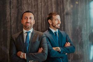 retrato de dos empresario en un traje con su brazos cruzado en un moderno oficina edificio. selectivo atención foto