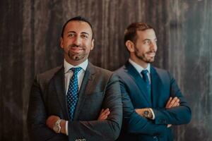 Portrait of two businessman in a suit with his arms crossed in a modern office building. Selective focus photo