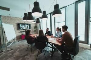 Successful team. Group of young multi-ethnic business people working and communicating together in creative office. Selective focus photo