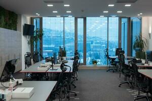 Front view of coworking office interior with workplaces, blank picture frame on wall and computer. photo