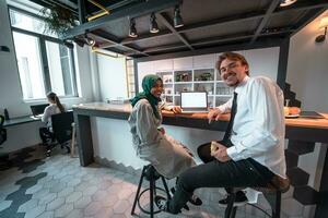 equipo de negocios multicultural internacional. un joven hombre y una mujer de negocios se sientan en un espacio moderno de relajación y hablan sobre un nuevo negocio. foto