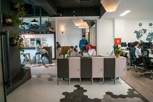 Group of casual multiethnic business people taking break from the work doing different things while enjoying free time in relaxation area at modern open plan startup office photo