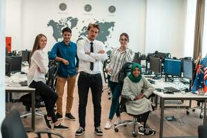 Portrait of young excited multiethnics business team of software developers standing and looking at camera at modern startup office photo