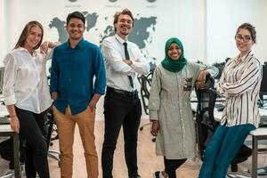 Portrait of young excited multiethnics business team of software developers standing and looking at camera at modern startup office photo