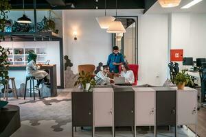 Group of casual multiethnic business people taking break from the work doing different things while enjoying free time in relaxation area at modern open plan startup office photo