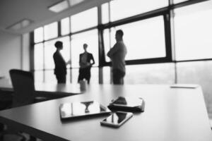 close up of tablet, business people on meeting in background photo