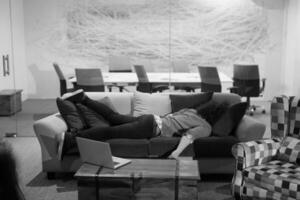 man sleeping on a sofa  in a creative office photo