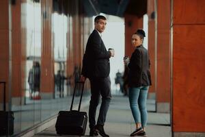 Two businessmen walk around town drinking coffee photo