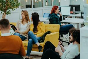 Group of multi-ethnic colleagues working on desktop computers, laptop and sharing their ideas in a modern office space.Young influencers work on online marketing projects. photo