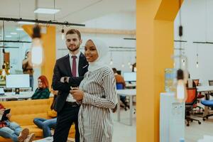 Portrait of a formal businessman and young African American businesswoman posing with their team in a modern startup office. Marketing concept. Multi-ethnic society. photo