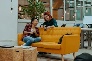 group of female friends having a team meeting and discussion about project or gossip chatting in modern startup business office photo