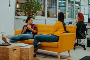 group of female friends having a team meeting and discussion about project or gossip chatting in modern startup business office photo