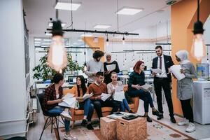 Group of multi-ethnic colleagues working on desktop computers, laptop and sharing their ideas in a modern office space.Young influencers work on online marketing projects. photo