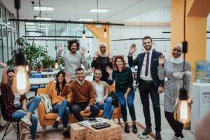 Group of multi-ethnic colleagues working on desktop computers, laptop and sharing their ideas in a modern office space.Young influencers work on online marketing projects. photo