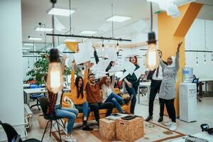 Group of business people throwing paper in air at modern startup office, team success and job done concept photo