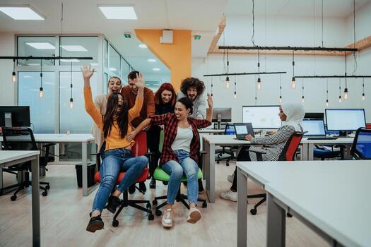 Team building and office fun. Young cheerful businesspeople in smart casual wear having fun while racing on office chairs and smiling. photo