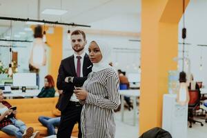 Portrait of a formal businessman and young African American businesswoman posing with their team in a modern startup office. Marketing concept. Multi-ethnic society. photo