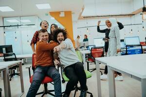 equipo edificio y oficina divertida. joven alegre gente de negocios en inteligente casual vestir teniendo divertido mientras carreras en oficina sillas y sonriente. foto