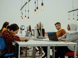 multiétnico grupo de empleados trabajando en un márketing compañía. un grupo de colegas es trabajando en un proyecto en moderno oficinas foto