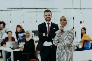 Portrait of a formal businessman and young African American businesswoman posing with their team in a modern startup office. Marketing concept. Multi-ethnic society. photo