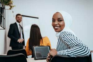 African American Muslim woman listens to a lecture aimed at business training photo