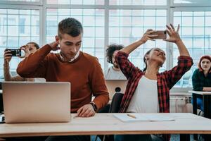 A group of diverse young men and women sit in a modern classroom and listen to a lecture on business training photo