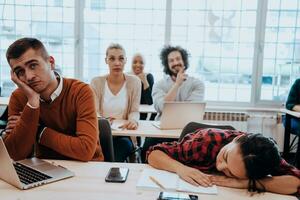 Tired woman napping on the table during a lecture in the classroom photo