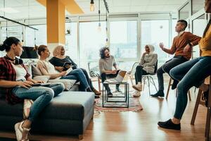 Young designer giving some new ideas about project to his partners in conference room. Business people discussing over new business project in office. photo