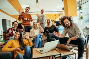 Group of multi-ethnic colleagues working on desktop computers, laptop and sharing their ideas in a modern office space.Young influencers work on online marketing projects. photo