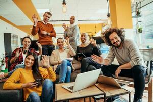 Group of multi-ethnic colleagues working on desktop computers, laptop and sharing their ideas in a modern office space.Young influencers work on online marketing projects. photo