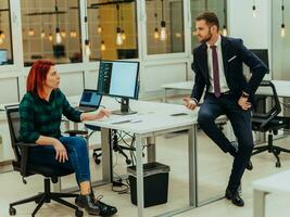 Two Creative office workers collaborate together to discuss main ideas for creating businness investment plan, analyze presentation on laptop computer photo