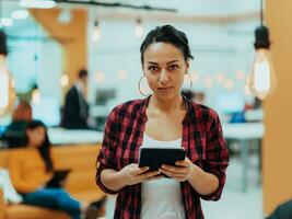 trabajando difícil No importar el tiempo. Disparo de un joven atractivo mujer de negocios trabajando tarde a noche en un moderno oficina. foto