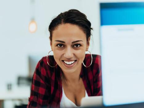 Woman sitting at workplace desk holds smartphone staring at laptop, synchronize data between computer and gadget in office, using corporate devices and business application, plan work, using organizer photo