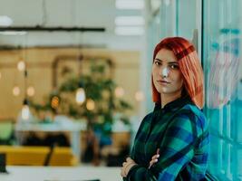 Headshot portrait of a modern woman with crossed arms in the office at night by the window photo