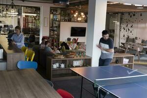 jugar al tenis de ping pong en el espacio de la oficina creativa foto