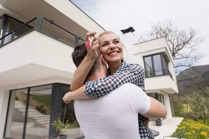 couple hugging in front of  new luxury home photo