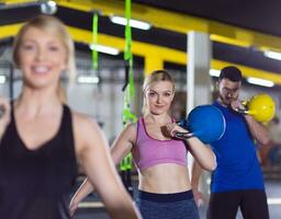 athletes doing exercises with kettlebells photo