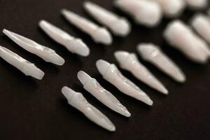 Prosthetic dentistry White teeth on black background Oral dental hygiene Dental health concept Oral care teeth restoration top view. photo