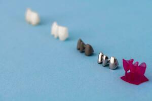 Teeth implant and crown installation process parts isolated on a blue background. Medically accurate 3D model. photo