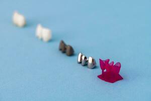 Teeth implant and crown installation process parts isolated on a blue background. Medically accurate 3D model. photo