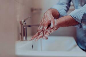 hombre utilizando jabón y Lavado manos debajo el agua grifo. higiene concepto mano de cerca detalle. foto