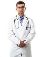 Portrait of hero in white coat. Cheerful smiling young doctor with stethoscope in medical hospital standing against white background. Coronavirus covid-19 danger alert photo