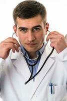 Confident male doctor in white lab coat and stethoscope standing with folded arms smiling at the camera isolated on white photo